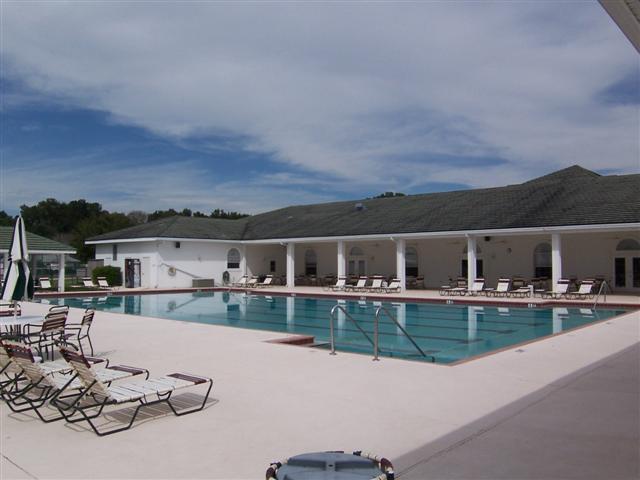 Ocala Palms Pool with chairs on one side and clubhouse opposite